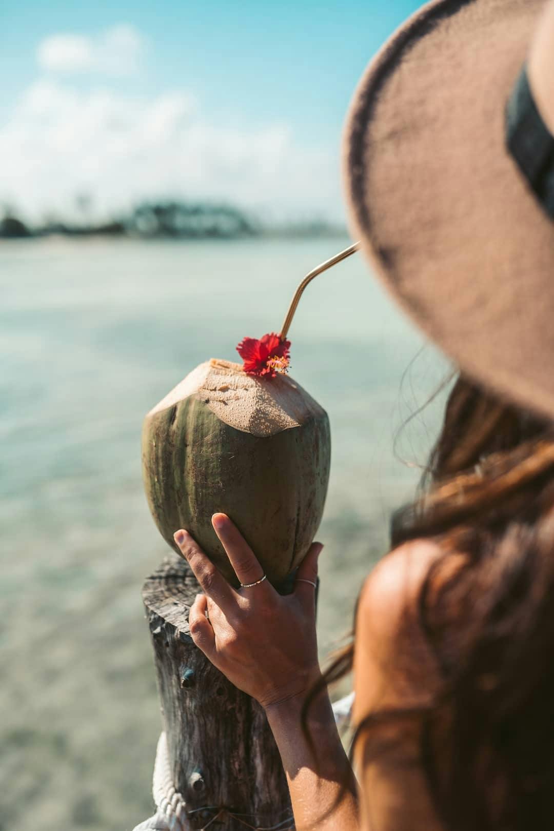 A girl drinking coconut juice on the beach
